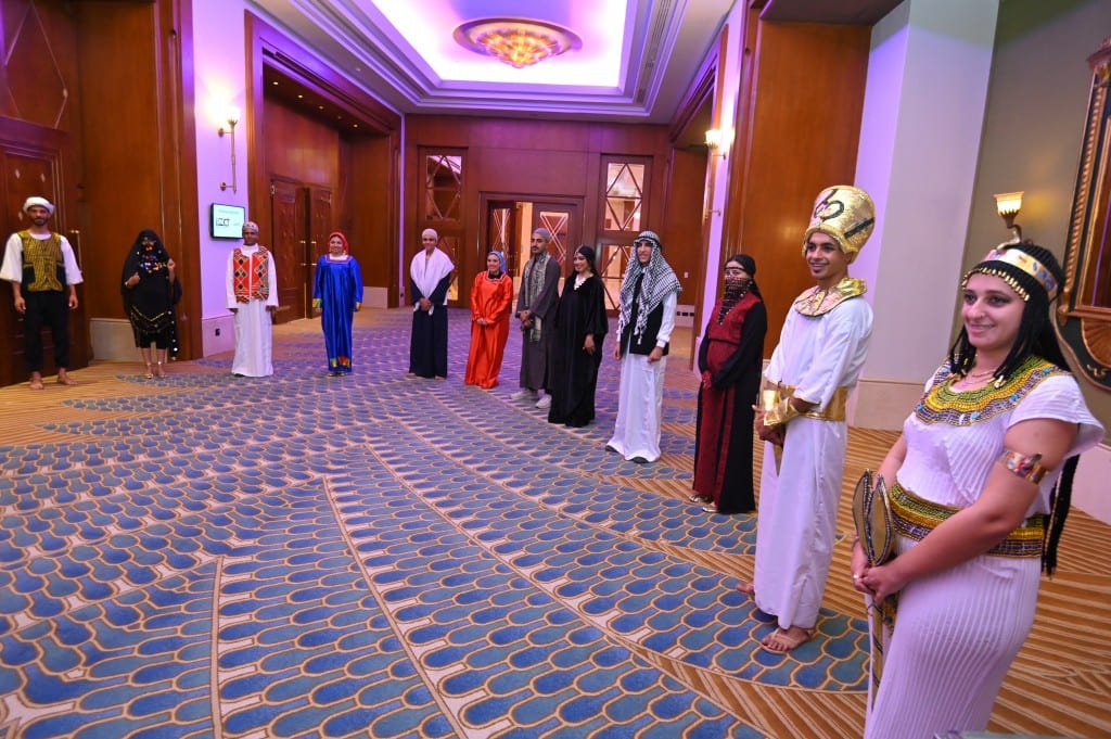 A line of hosts in pharaonic and traditional costume welcomes delegates in the ballroom